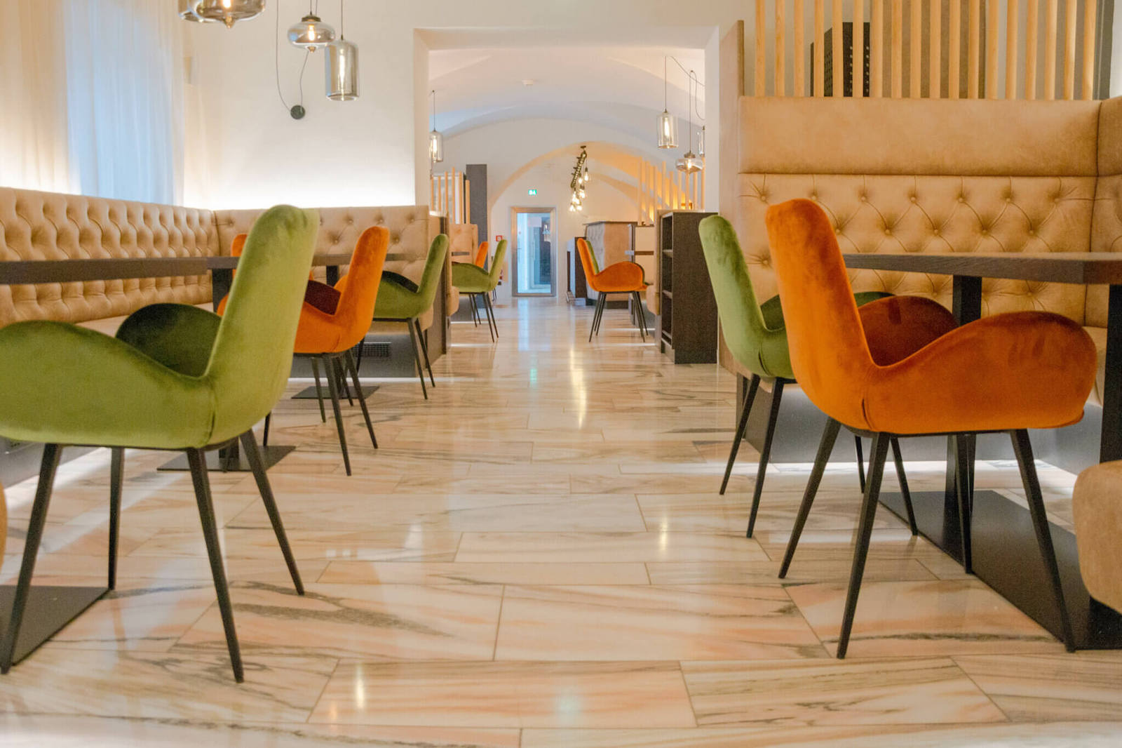 Warmes Licht und klassisch-elegantes Chesterfield wird mit modernen Elementen und kontrastreichen Farben kombiniert und sorgt für eine gemütliche, dennoch zeitlose Wohlfühl-Atmosphäre im historischen Innenbereich des Restaurants.